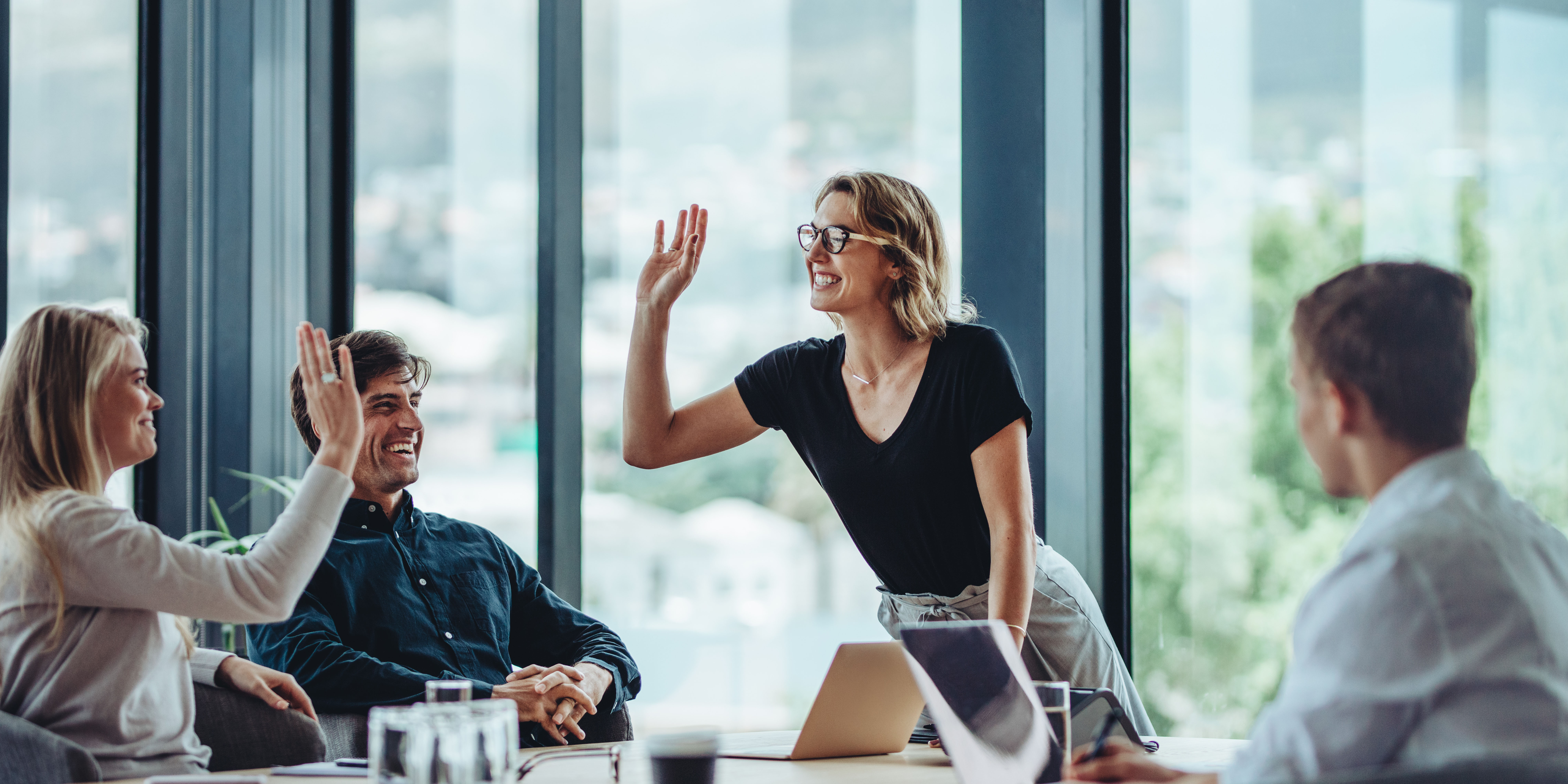 Woman high fiving co-workers.