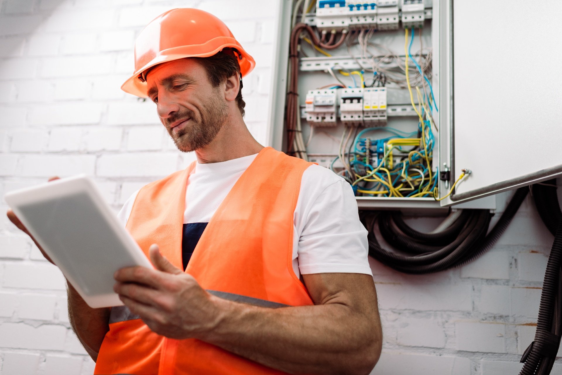 electrician using tablet near electrical box